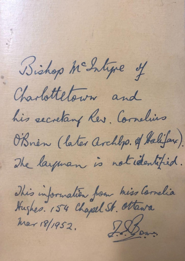 Reverse of the photograph of the three men. A caption is handwritten in ink. It reads: "Bishop McIntyre of Charlottetown and his secretary Rev. Cornelius O'Brien (later Archbishop of Halifax). The layman is not identified. This information from Miss Cornelia Hughes. 154 Chapel St. Ottawa. Mar 18/1952." There is an illegible signature in the bottom righthand corner.
